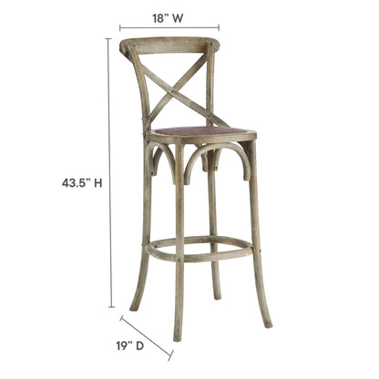 Rustic gray-washed wooden bar stool with cross-back, round padded brown seat, curved legs and footrest ring.