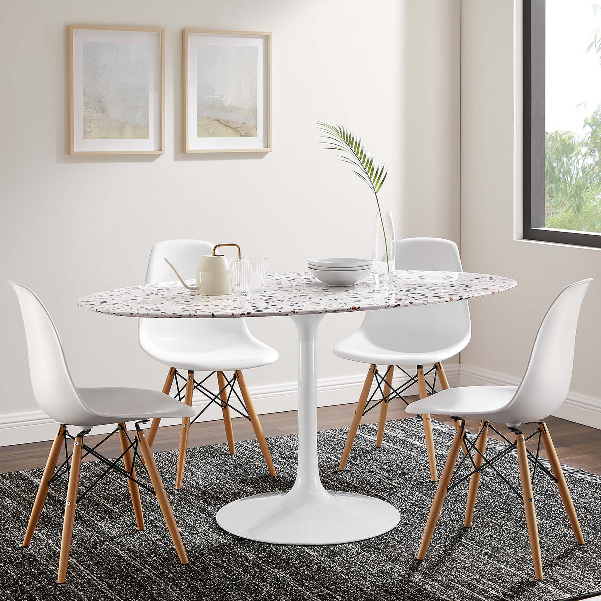Oval speckled terrazzo dining table on a white pedestal base, surrounded by white molded-shell chairs with wooden legs (60 inches long).