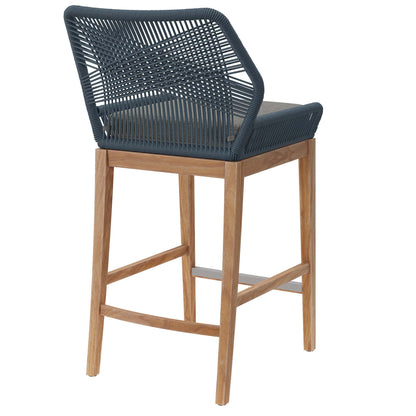 Gray woven rope bar stool with teak wood legs, metal footrest, and gray cushion.