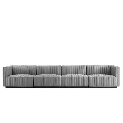 Light gray modular sectional sofa with channel-tufted cushions and low-profile arms.