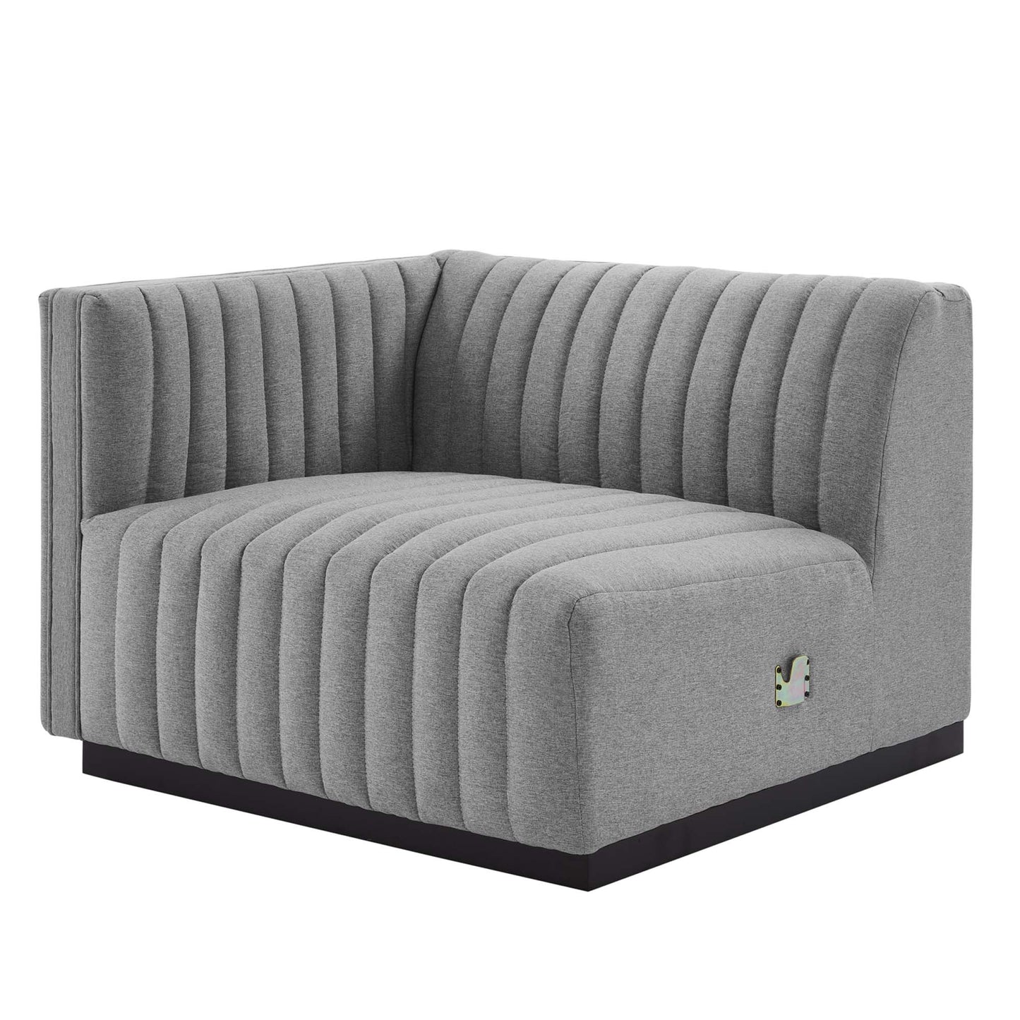 Gray L-shaped corner sofa with vertical channel tufting and a low black base.