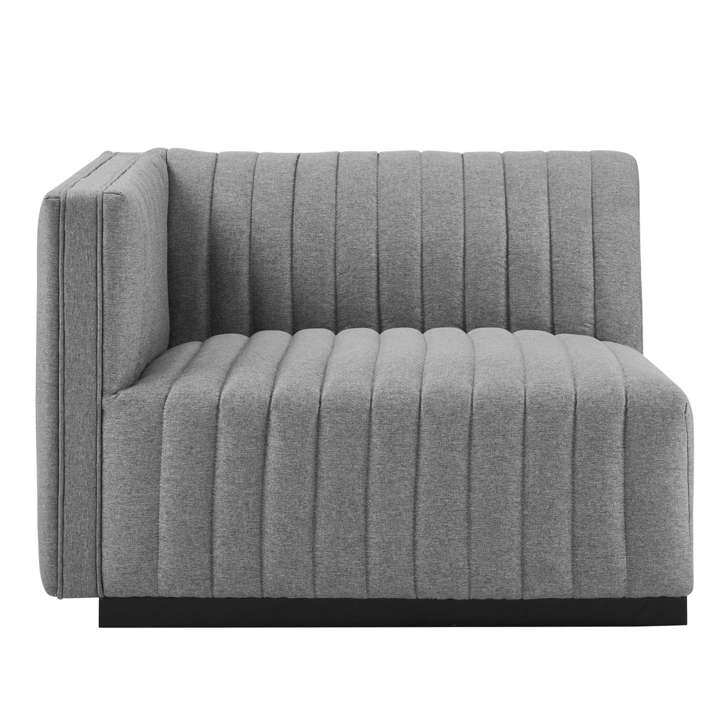 Grey fabric modular sofa with vertical channel tufting and a low black platform base.