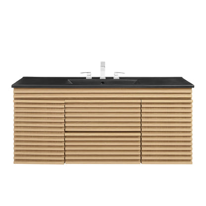 Oak slat-front wall-mount bathroom vanity with black countertop and dual sinks, chrome faucet fixtures.