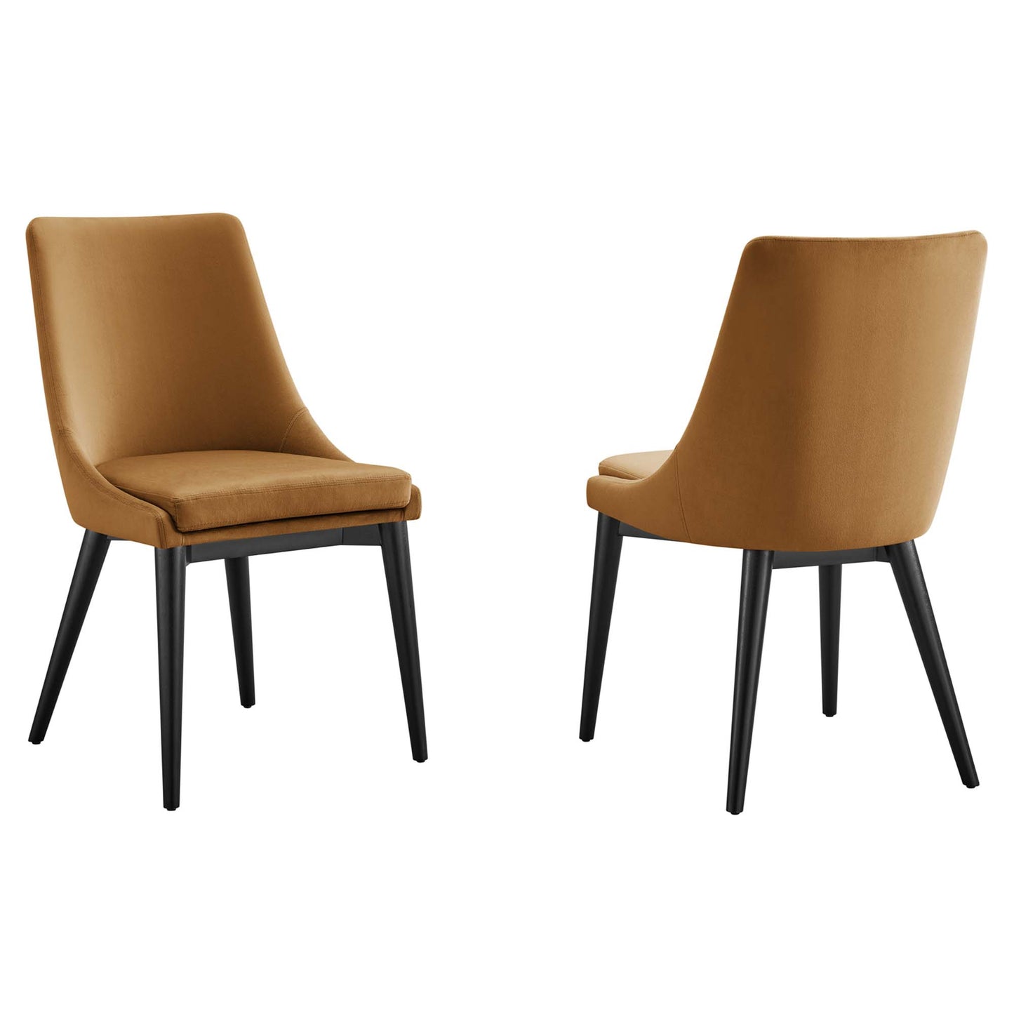 Two caramel-brown velvet upholstered dining chairs with curved backs and black tapered legs, mid-century style.