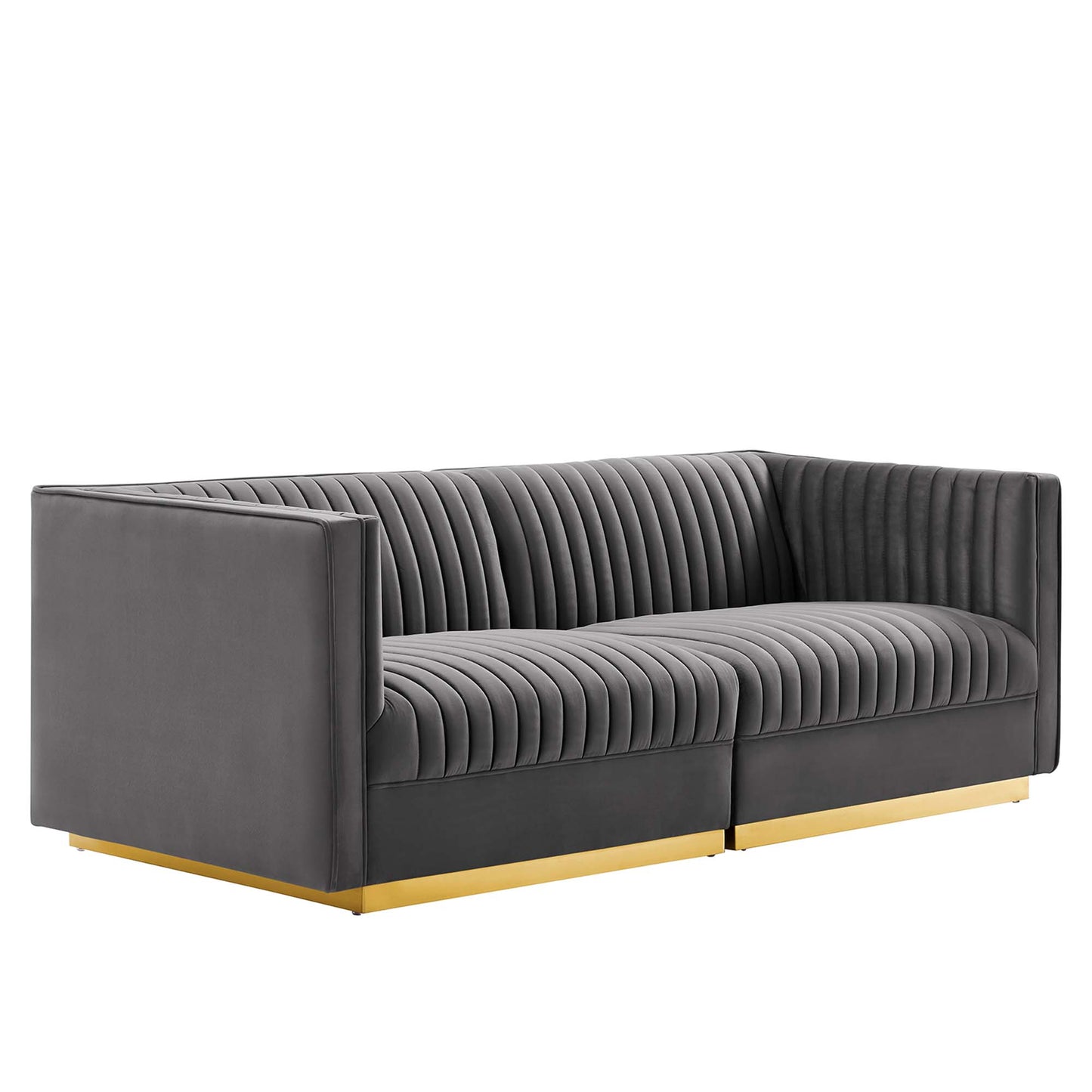 Grey fabric sofa with vertical channel tufting, low square arms, and gold metal base rails