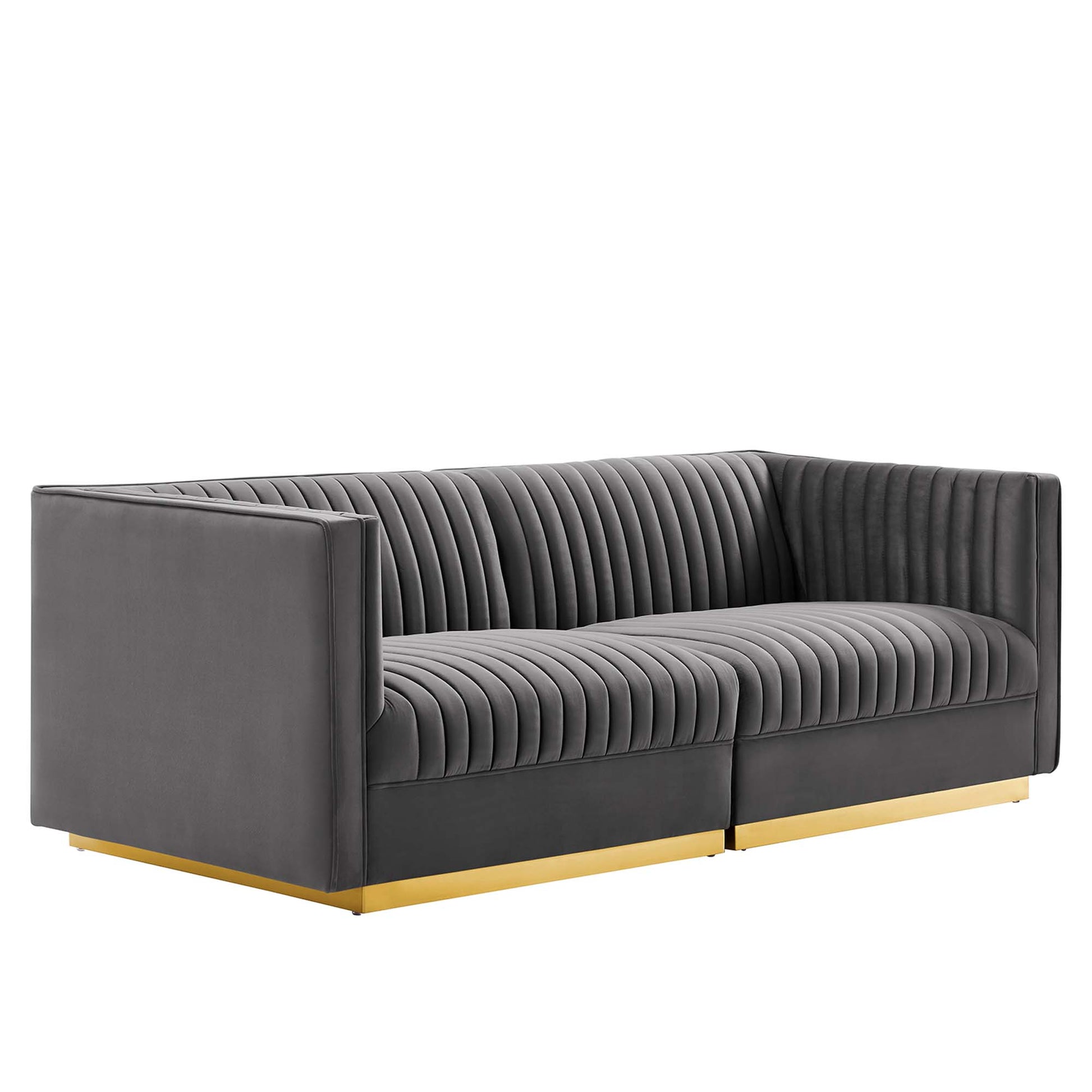 Grey fabric sofa with vertical channel tufting, low square arms, and gold metal base rails