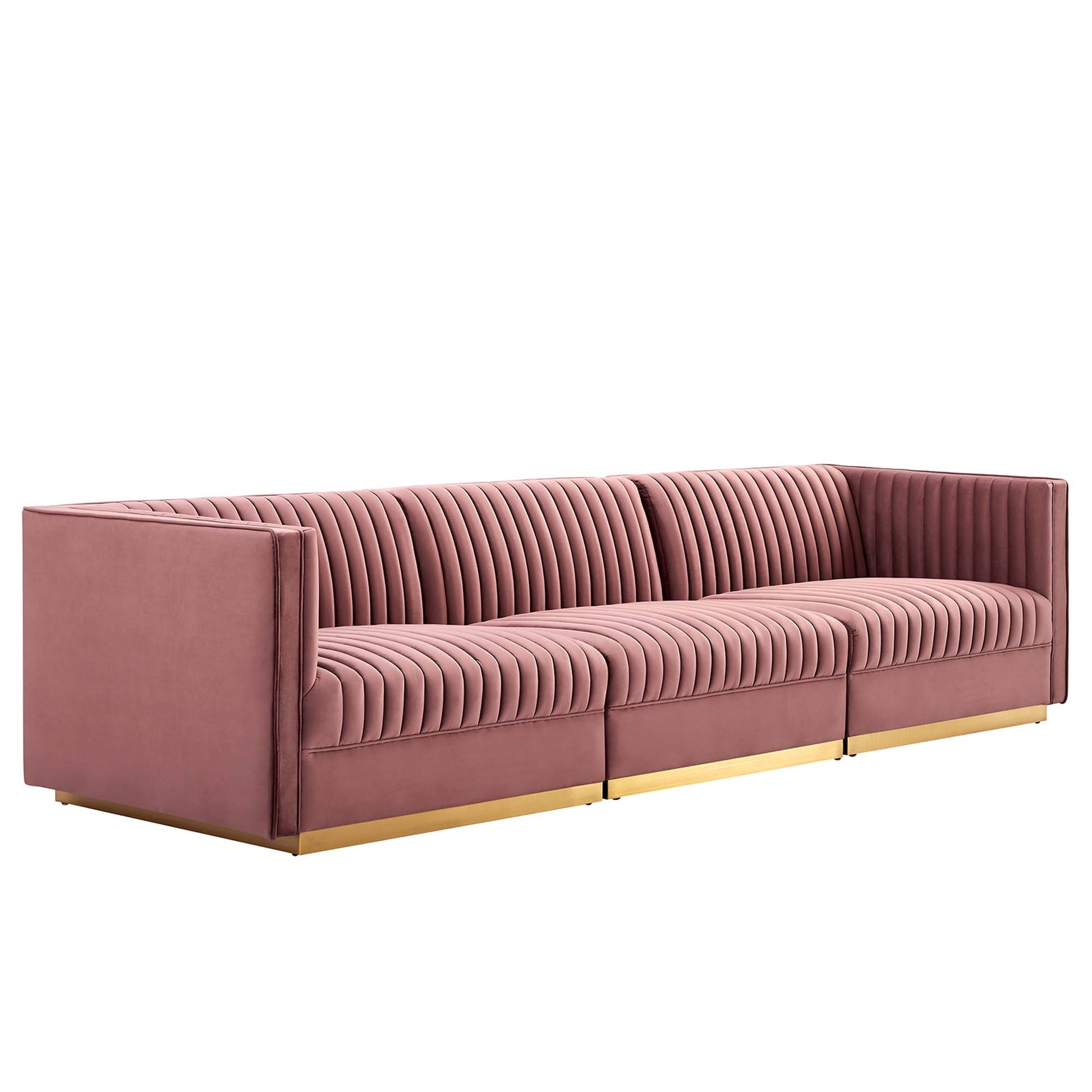 Red velvet sofa with vertical channel tufting, modular three-seat layout, low square arms and gold metal legs.