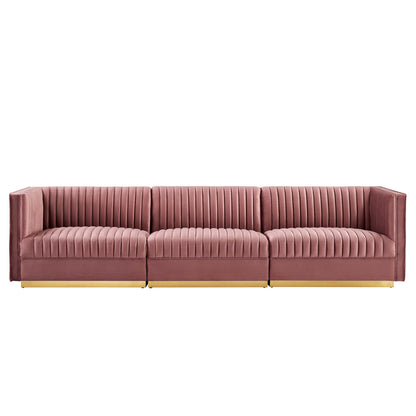 Red velvet 3-seat modular sectional sofa with vertical channel tufting, low squared arms and gold legs.