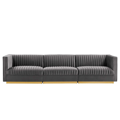 Grey fabric modular sofa with vertical channel tufting, three seats & light wood base.