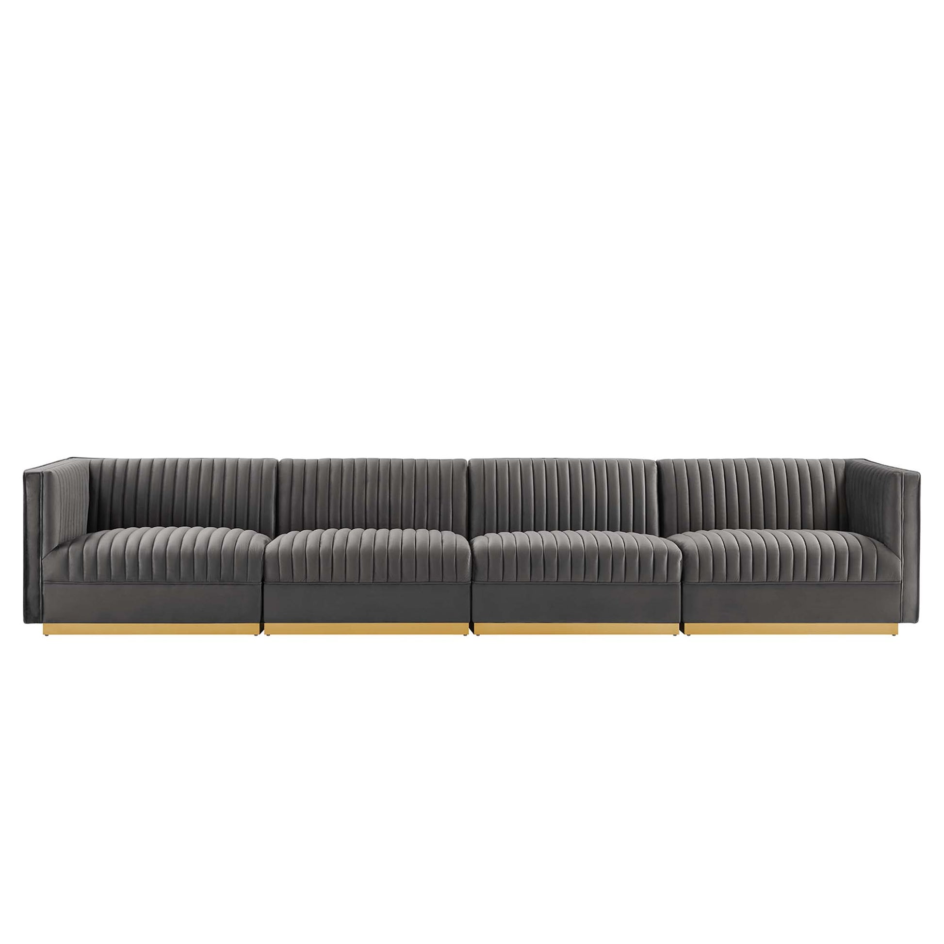 Long charcoal gray sectional sofa with vertical channel tufting, low arms, light wood legs.