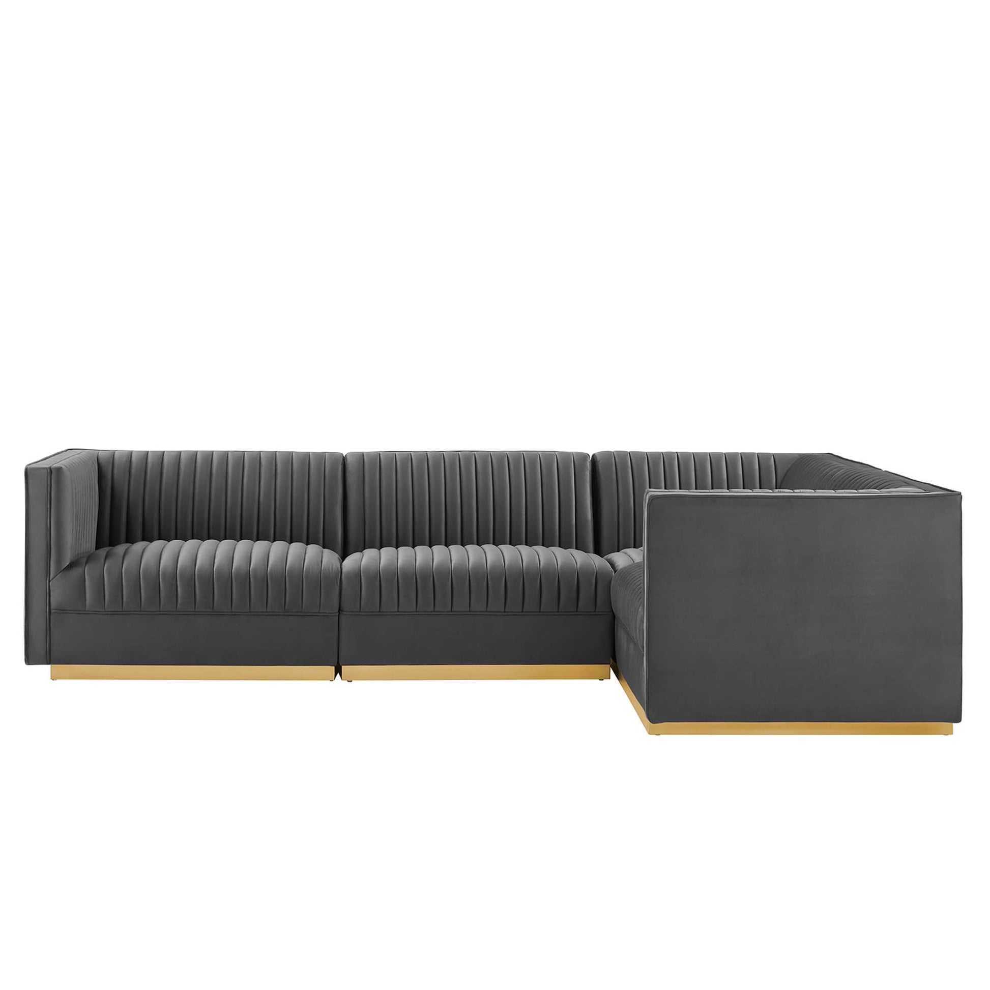 Dark gray velvet sectional with vertical channel tufting, right-facing L-shaped with chaise, light wood legs.