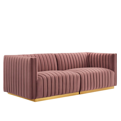 Pink velvet loveseat with vertical channel tufting, square arms, low profile, gold metal base.