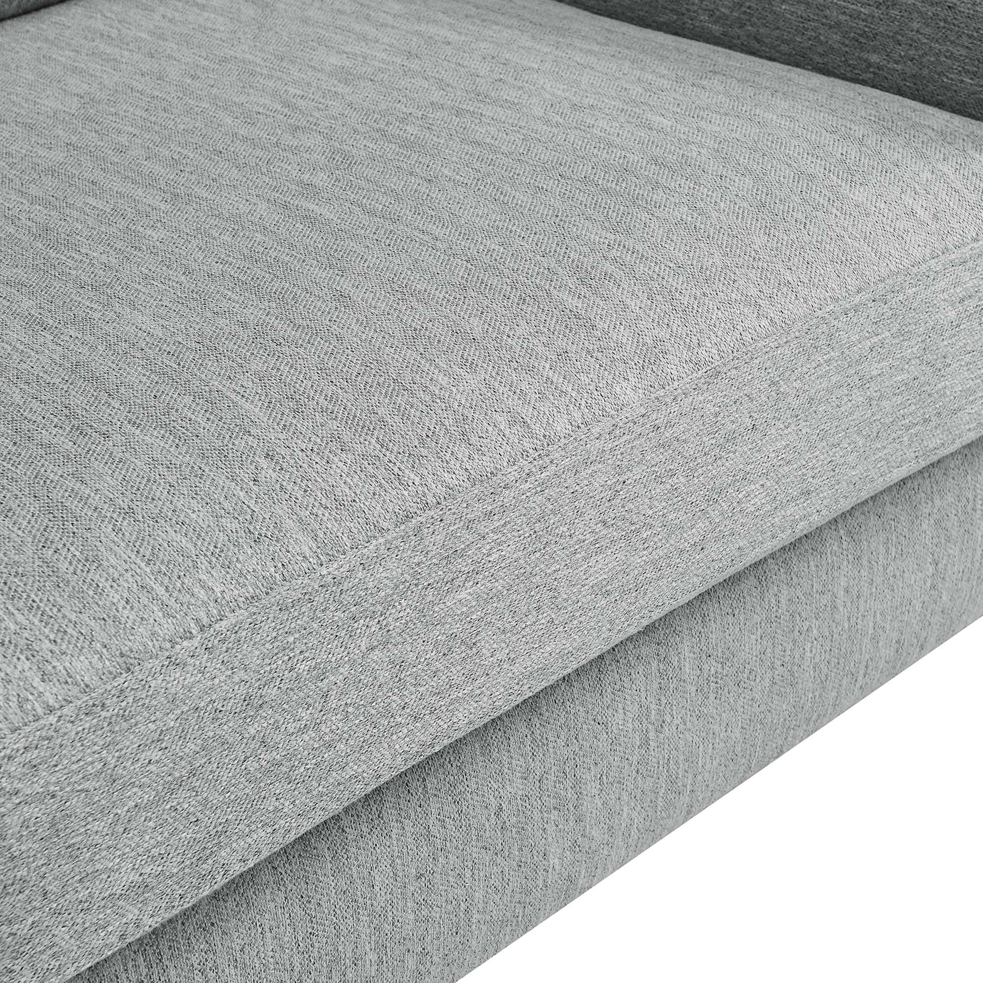 Close-up of seam edge on light gray textured fabric upholstery of a loveseat.