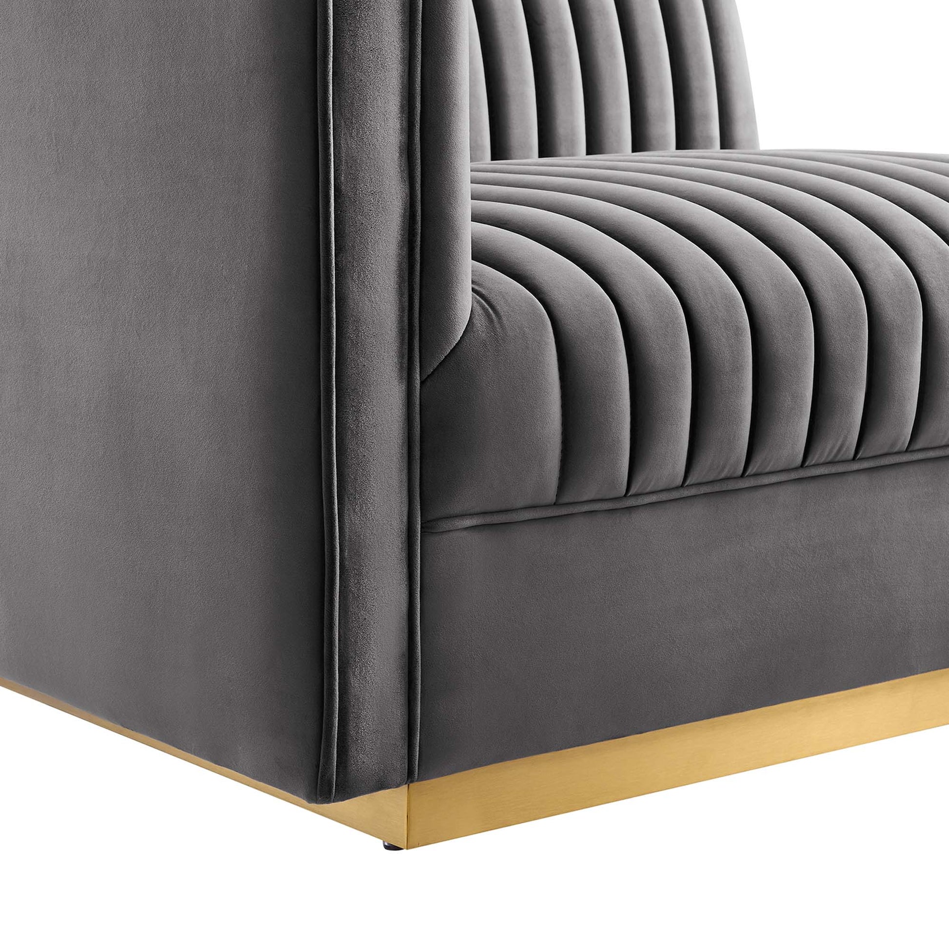 Dark gray velvet tufted modular sectional sofa with vertical channel detailing and gold metal base trim.