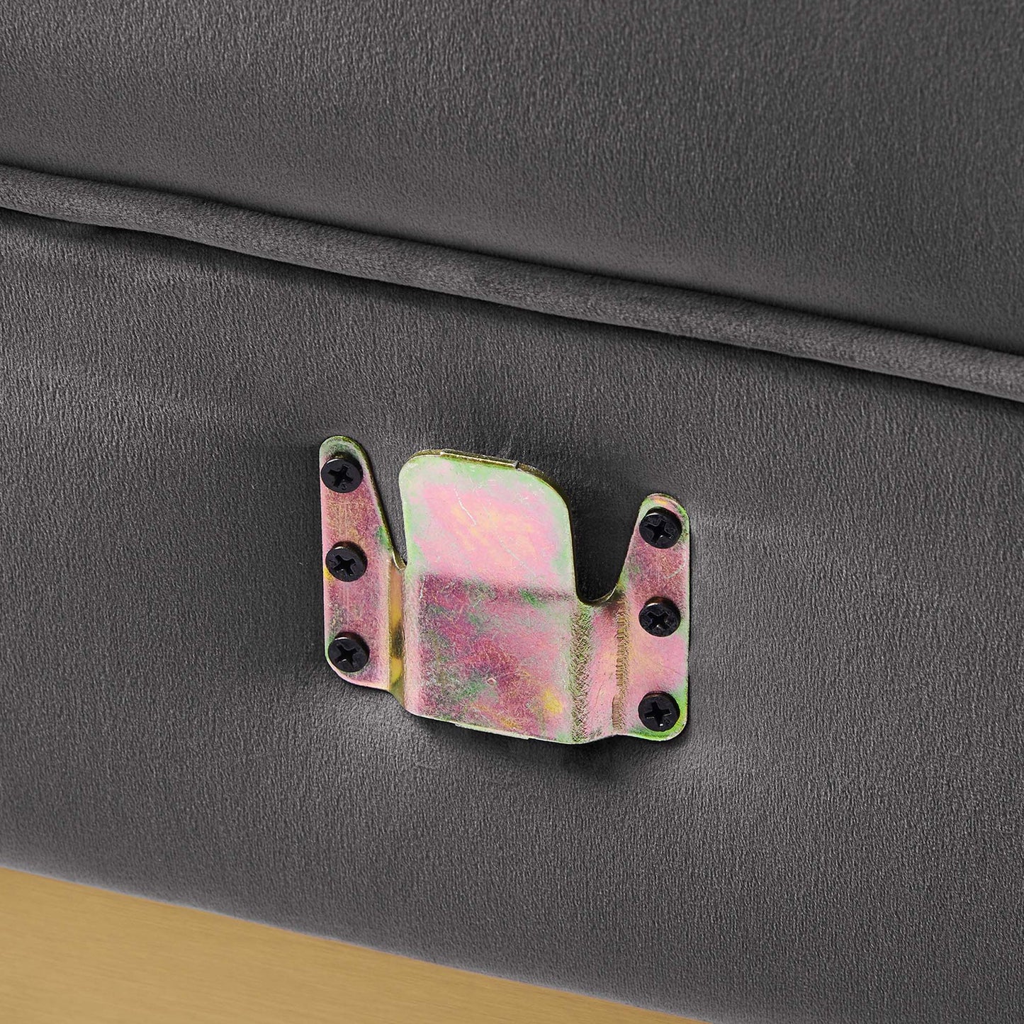 Iridescent metal latch bracket with dual side mounting plates and central clasp on gray velvet upholstery.
