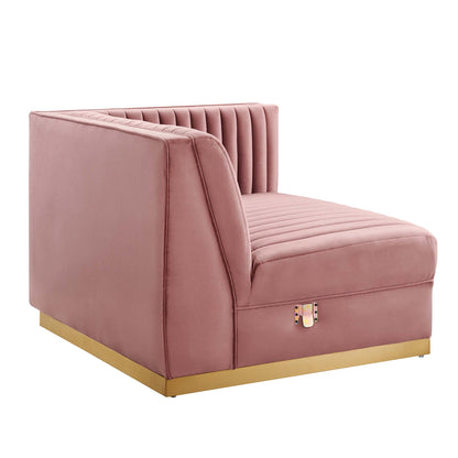Red velvet right-arm chair with vertical channel tufting and a gold metal base, as part of a modular sectional.