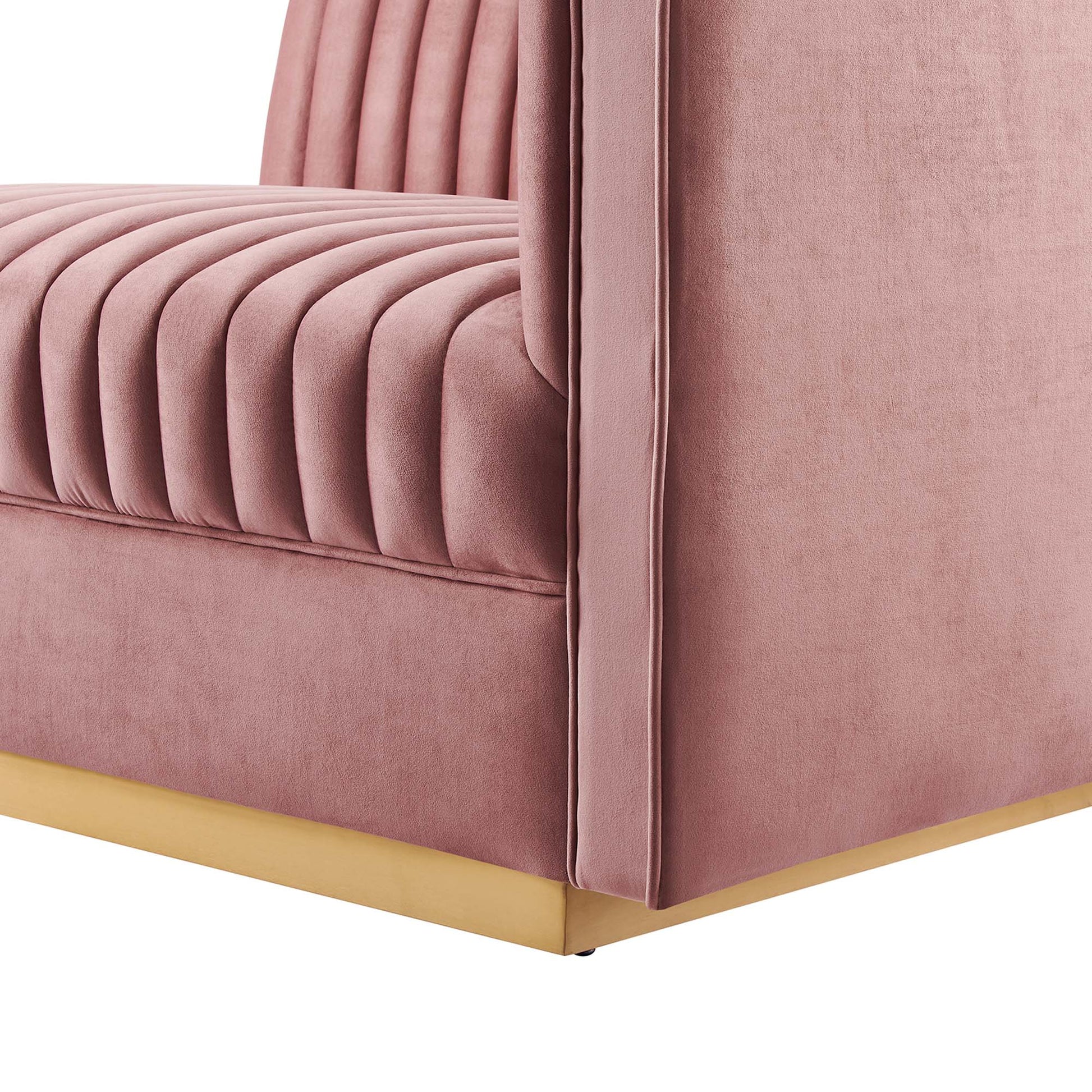 Dusty rose velvet sofa corner with vertical channel-tufted seat cushions and a gold-toned base.