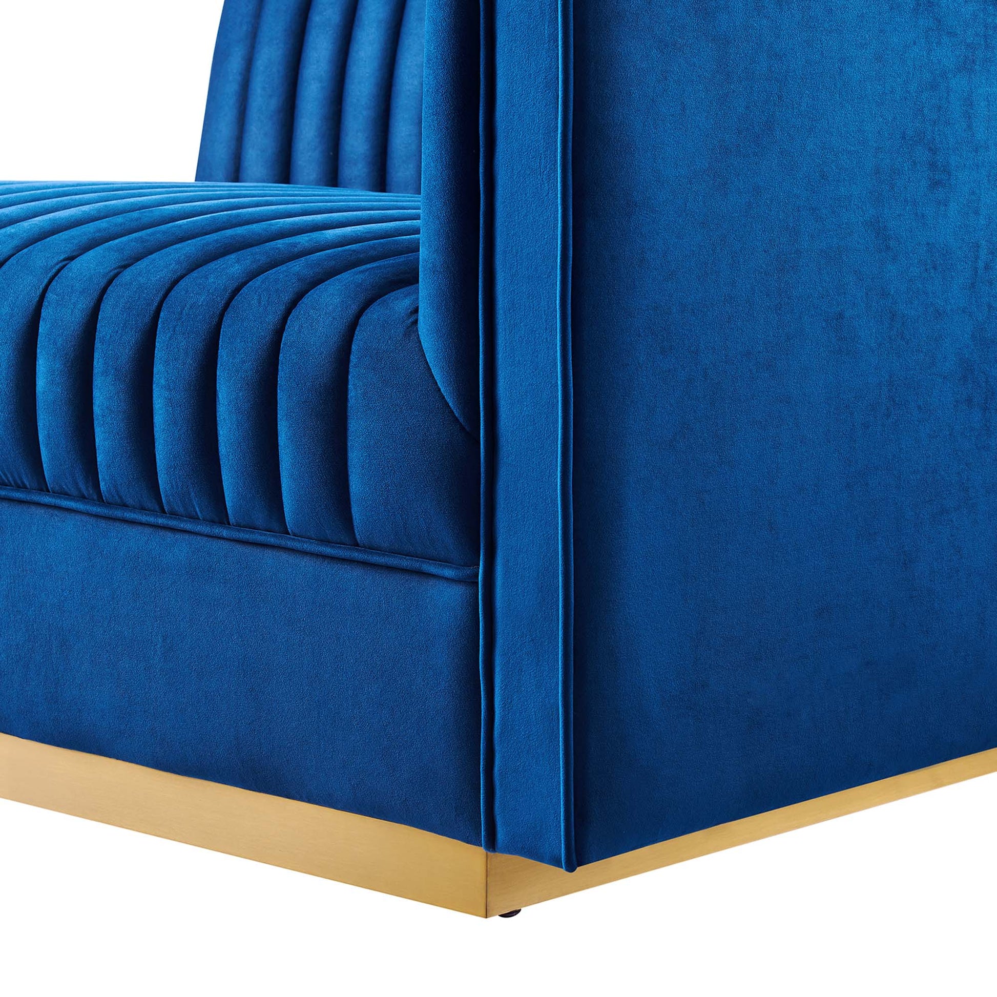 Navy blue velvet modular sectional sofa corner with vertical channel tufting and gold metal base trim.