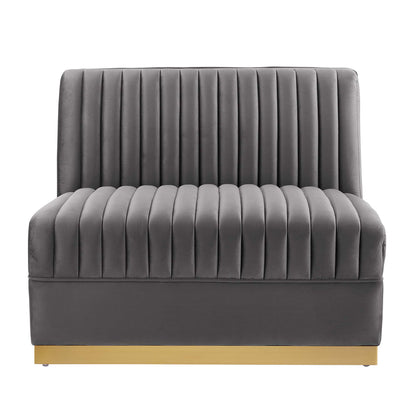 Gray velvet armless chair with vertical channel tufting on back and seat, on a light wood platform base.