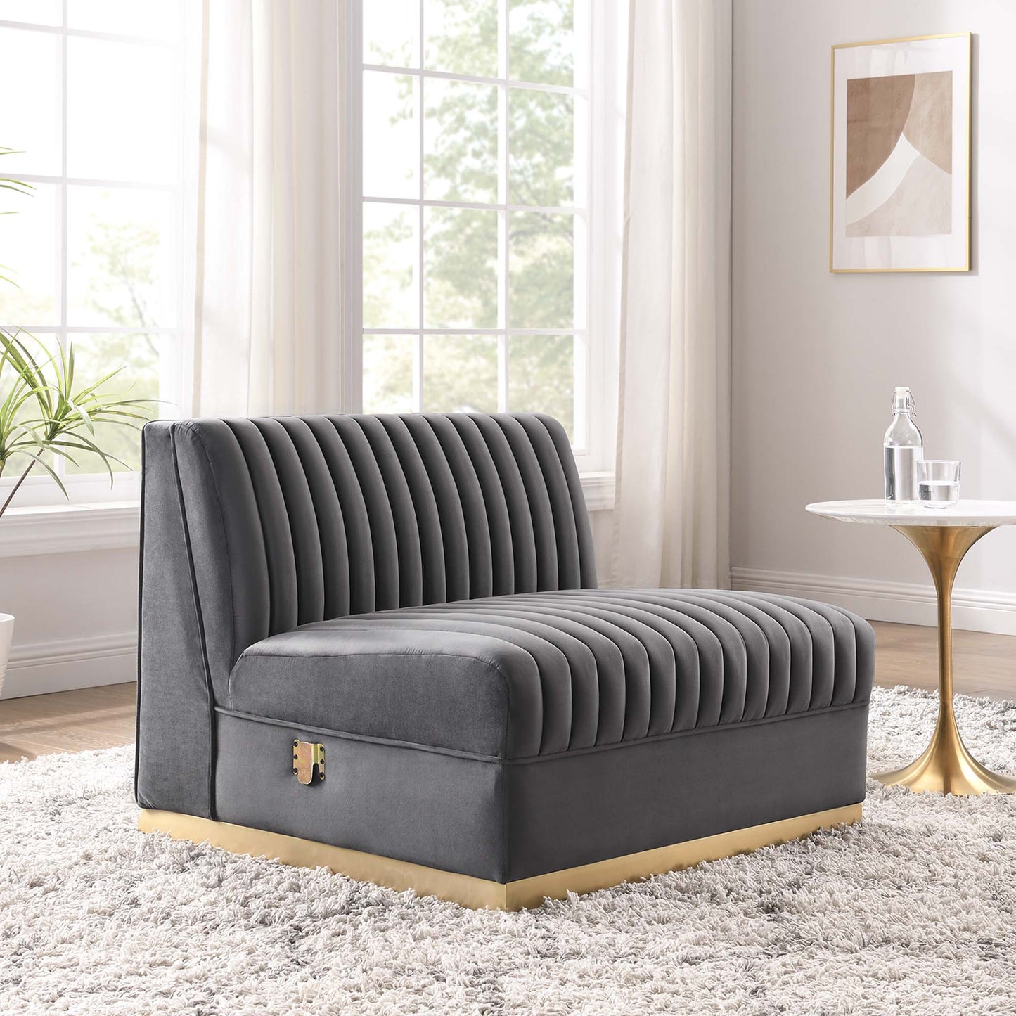 Gray velvet settee with vertical channel tufting and a gold base, modern lounge seating for a living room.