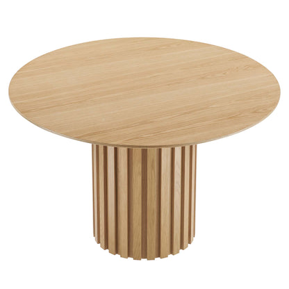 Round oak dining table with natural finish and a vertical slat drum pedestal.