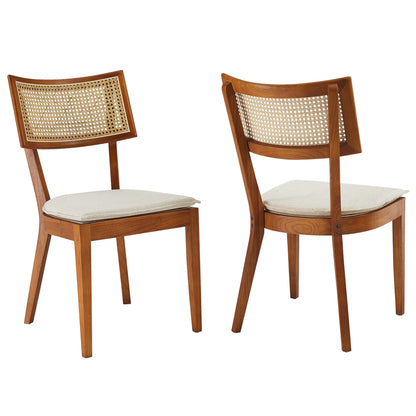 Pair of walnut wood dining chairs with caned backs and light beige cushioned seats.