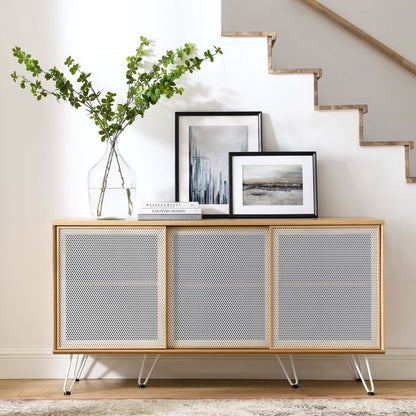 Oak-framed sideboard with four perforated panels, slim metal legs, topped with a vase of greenery and framed art.