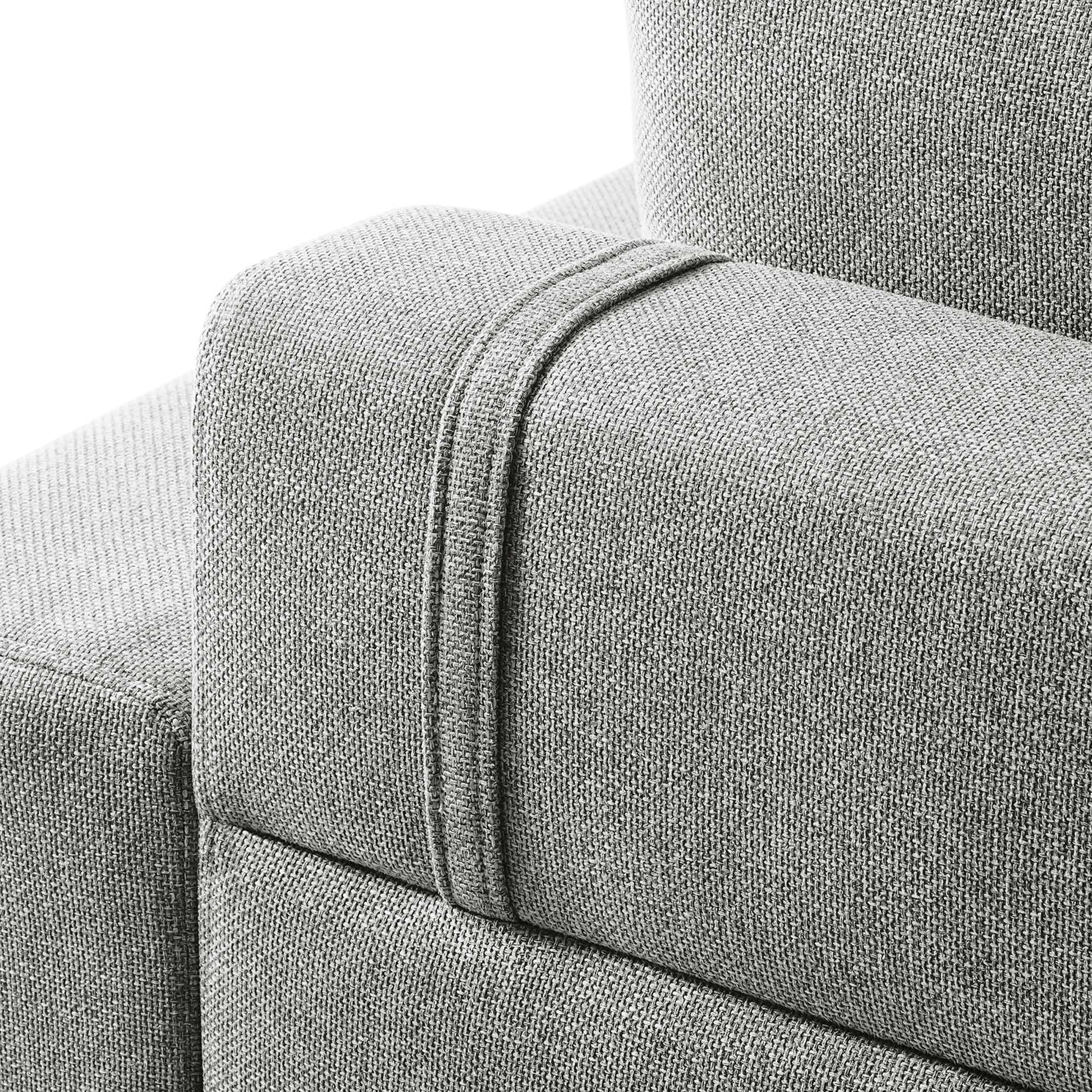 Light gray textured fabric sofa arm with a raised strap seam detail.