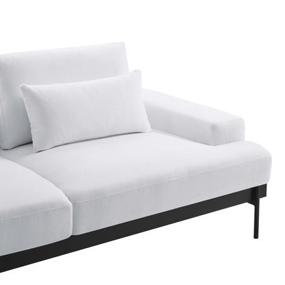 White fabric sofa with black metal legs, right-arm rest, and a matching throw pillow.