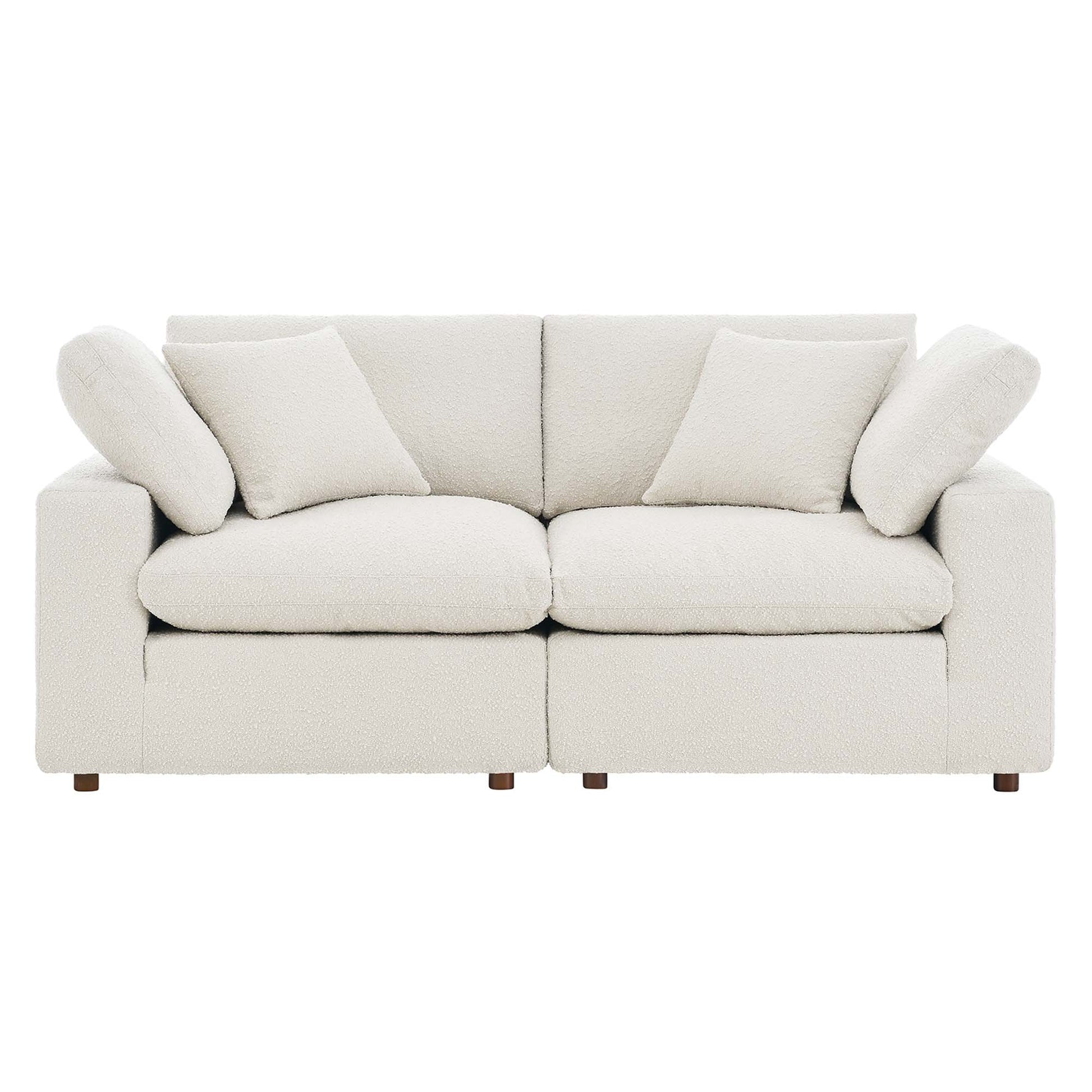 Ivory boucle fabric loveseat with straight square arms, two-seat cushions, two back cushions, and matching throw pillows.