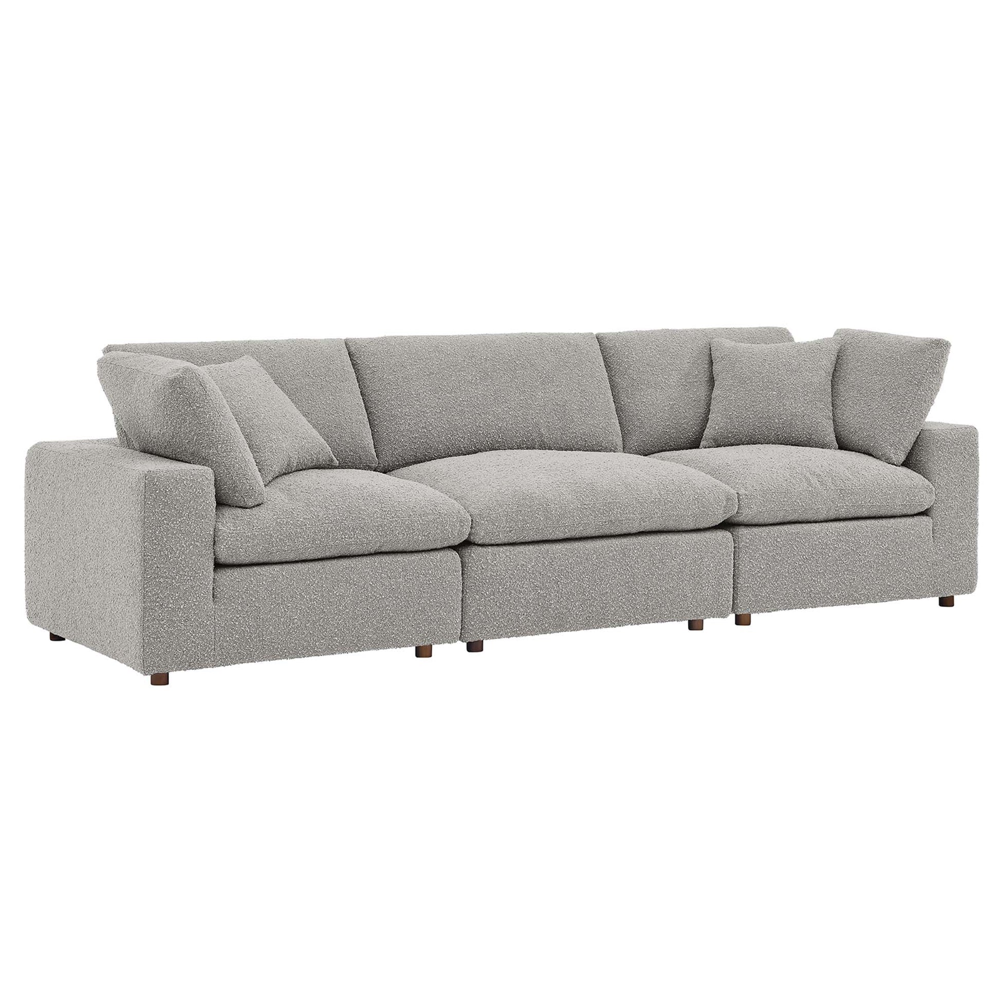 Gray fabric sofa with square arms, three-seat cushions, multiple back cushions, short wooden legs.
