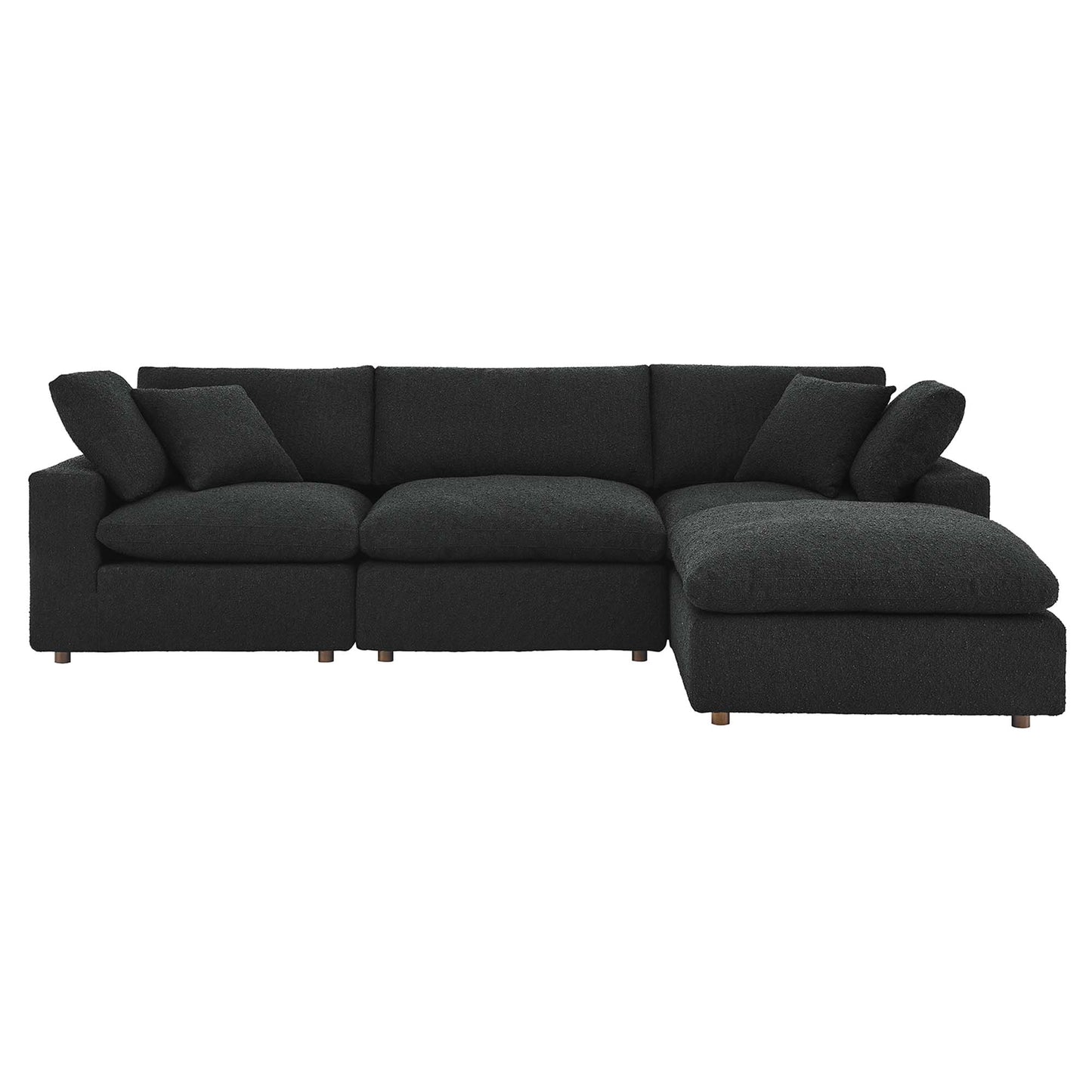 Black sectional sofa with chaise on the right, plush cushions and short wooden legs.