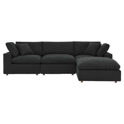Black sectional sofa with chaise on the right, plush cushions and short wooden legs.