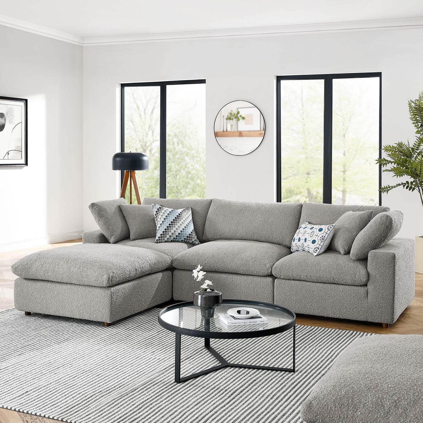 L-shaped gray boucle fabric sectional sofa with chaise, plush cushions, round glass coffee table, modern living room