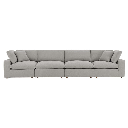 Long light gray boucle fabric sofa with six seat cushions, two throw pillows, low square arms and wooden legs.
