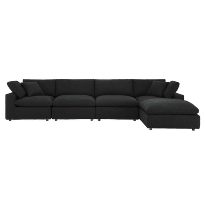 Black fabric sectional sofa with chaise on the right, modular sections, plush cushions, low wooden legs.
