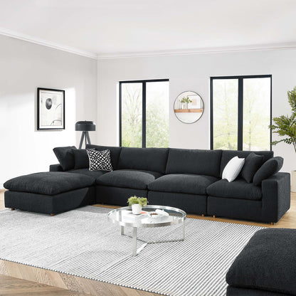 Black boucle fabric L-shaped 5-piece sectional sofa in a modern living room with a round glass coffee table & a striped rug.