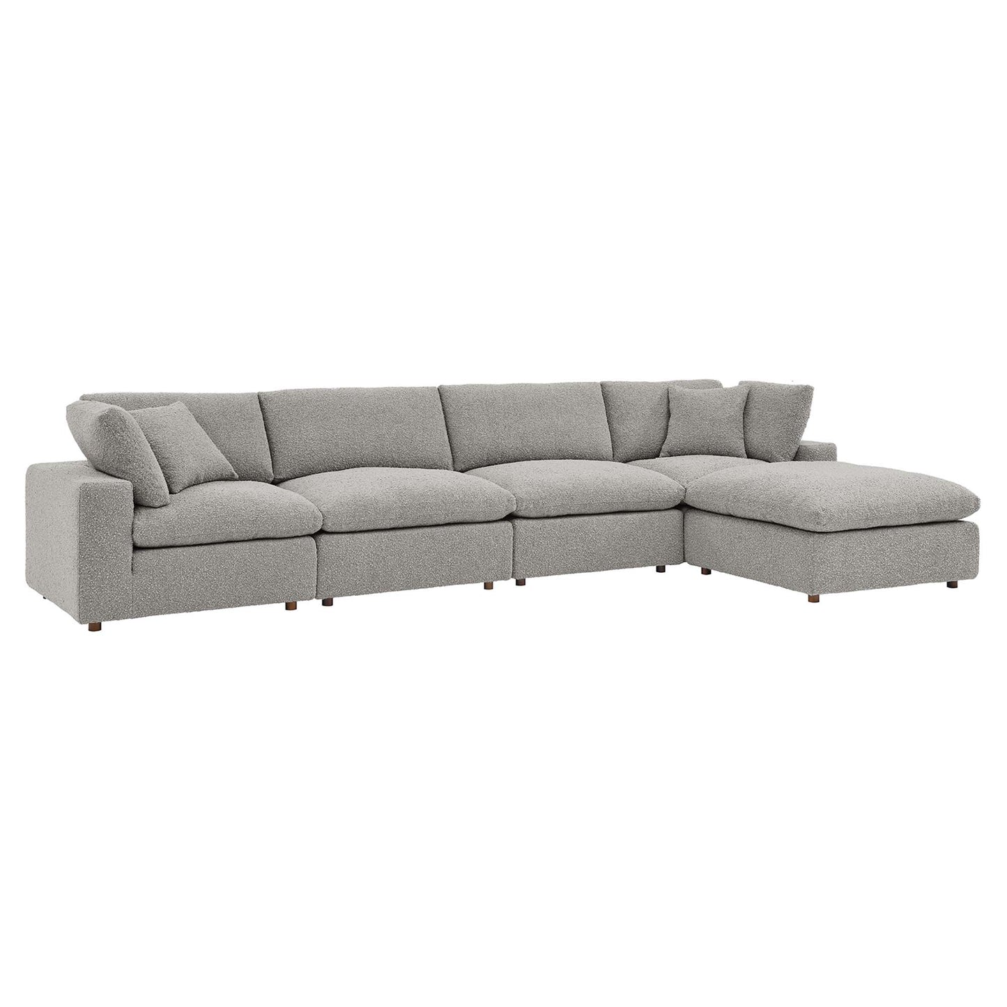 Light gray bouclé fabric sectional with a right-side chaise, plump cushions, and low-profile wooden legs.