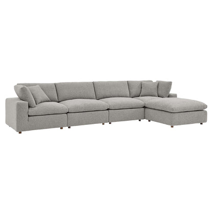 Light gray bouclé fabric sectional with a right-side chaise, plump cushions, and low-profile wooden legs.
