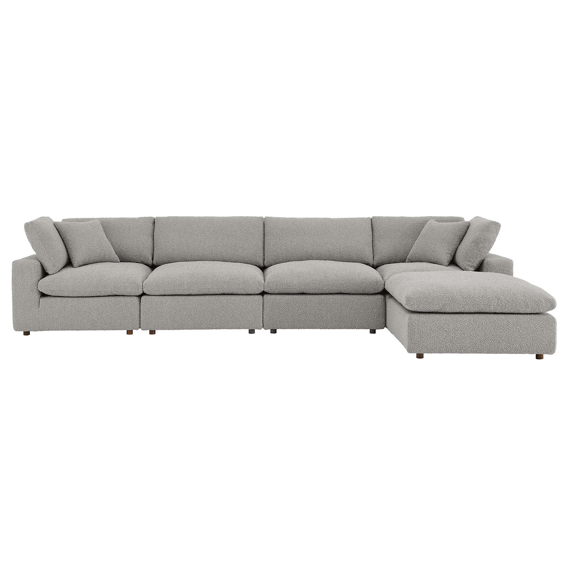 Light gray boucle fabric L-shaped sectional sofa with chaise on the right and overstuffed cushions.