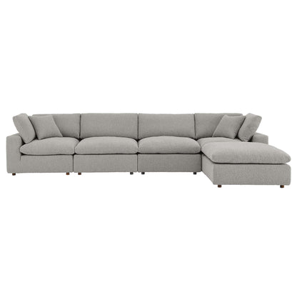 Light gray boucle fabric L-shaped sectional sofa with chaise on the right and overstuffed cushions.