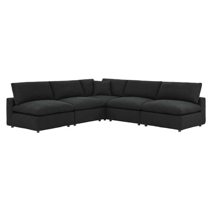Black L-shaped sectional sofa with chaise, down-filled overstuffed cushions, low arms, boucle fabric upholstery and wooden legs.