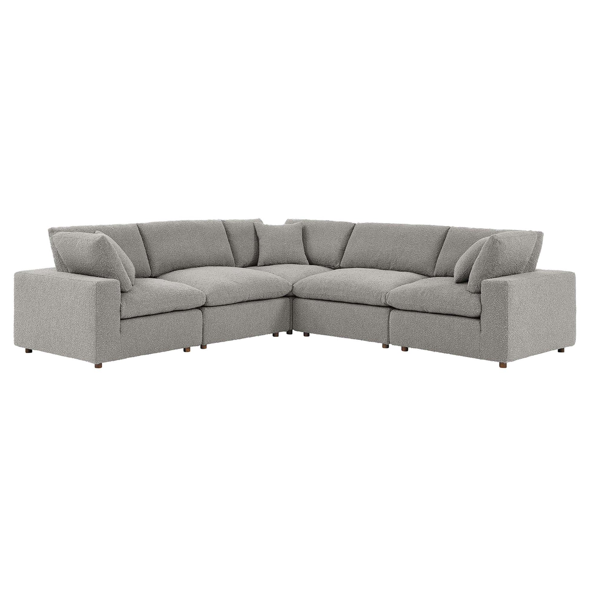 Gray boucle L-shaped sectional sofa with plush back cushions and short wooden legs.