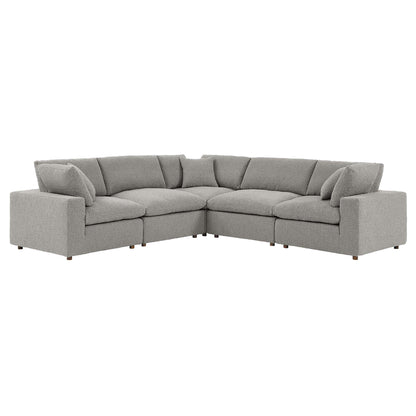 Gray boucle L-shaped sectional sofa with plush back cushions and short wooden legs.