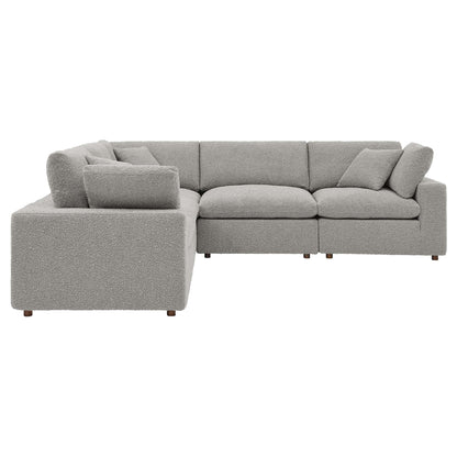 Gray boucle L-shaped sectional sofa with chaise, down-filled, overstuffed cushions, and wooden legs.