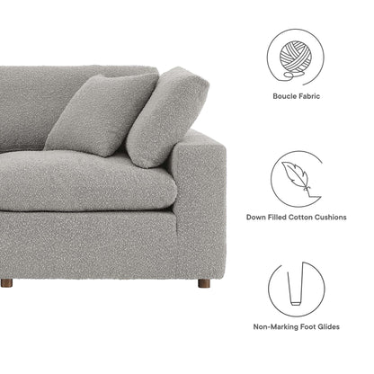 Gray boucle fabric sectional sofa with plush back cushions, boxy arms and wooden legs; down-filled cushions for comfort.
