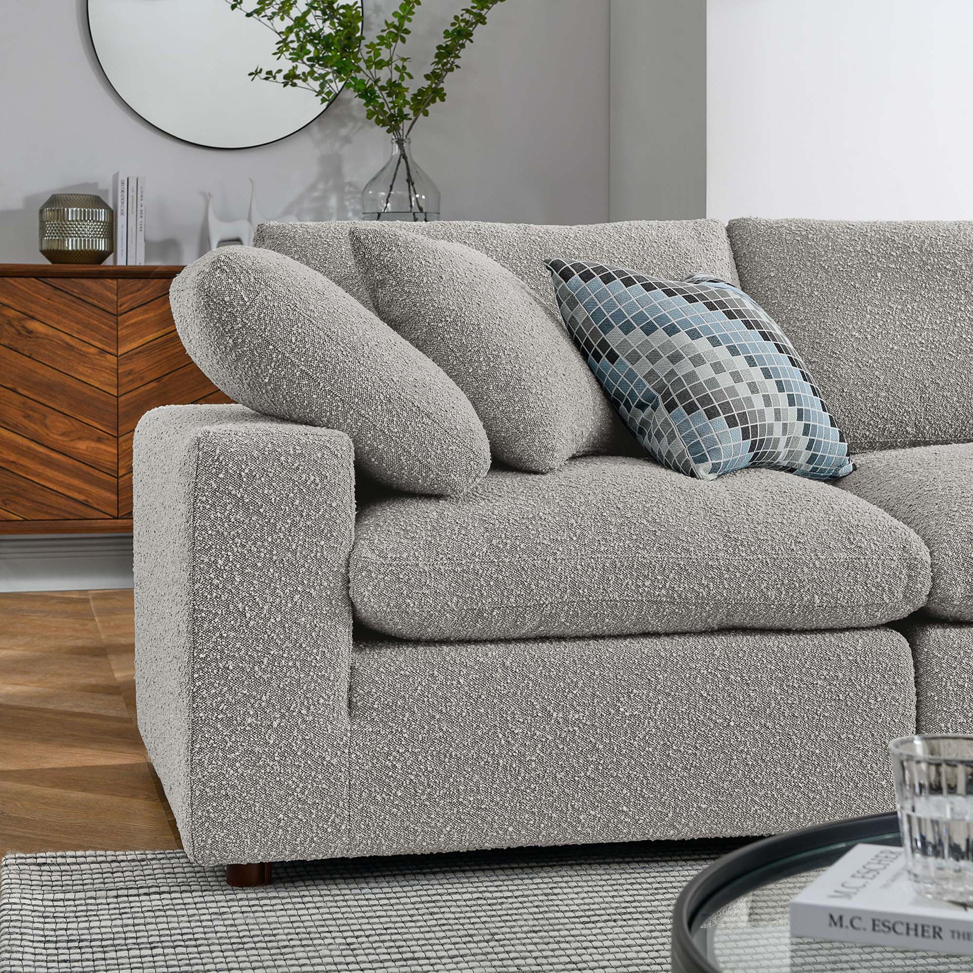 Light gray boucle fabric 5-piece sectional sofa with rounded arms, plush cushions and a blue check pillow in a modern living-room setting.