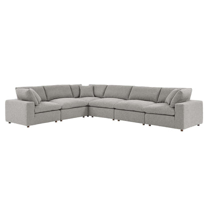 Light gray fabric L-shaped sectional sofa with plush back cushions and tapered wooden legs.