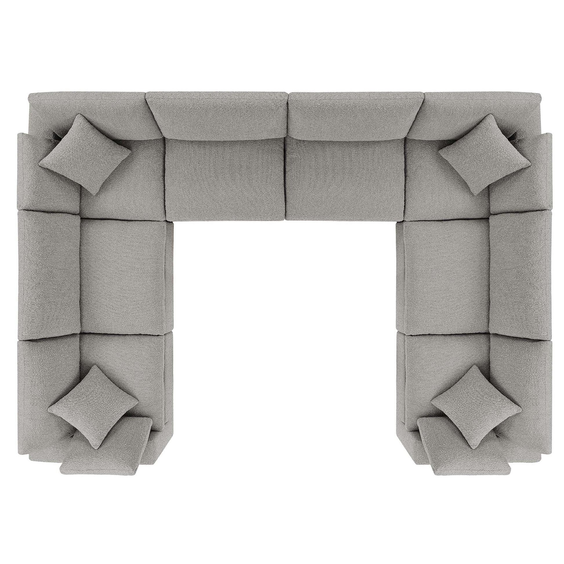 Light gray fabric modular sectional sofa in a U-shaped layout with square cushions and matching pillows.
