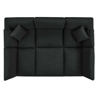 Dark charcoal boucle fabric sectional sofa with square tufted cushions and two matching throw pillows.